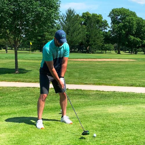 man getting ready to hit a golf ball down the fairway